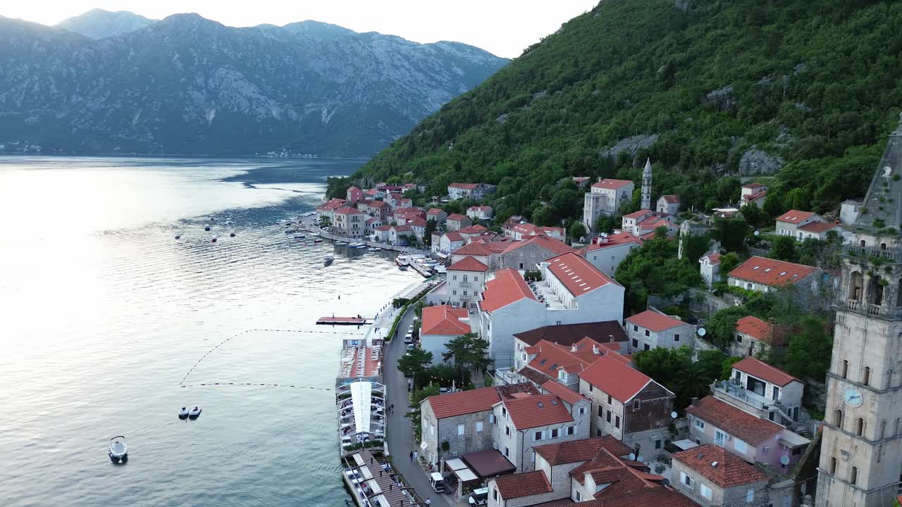 Pemandangan udara desa Perast di teluk Kotor yang dikelilingi oleh pegunungan kapur setelah matahari terbenam