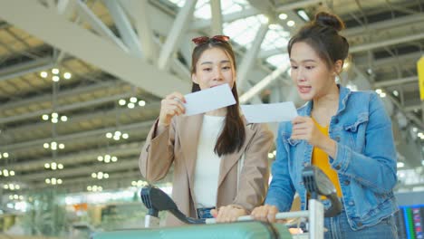 두 명의 여성이 공항에서 체크인하고 있습니다.