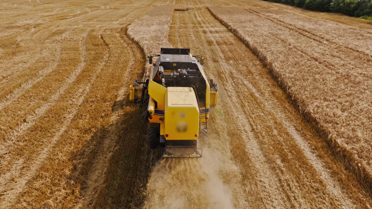 Aerial of yellow combine cutting golden wheat as metaphor for sustainability gap