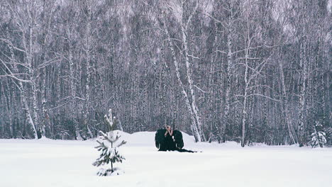 Una-Mujer-Vestida-Con-Un-Elegante-Traje-De-Fénix-Posa-Contra-Un-Bosque-Nevado