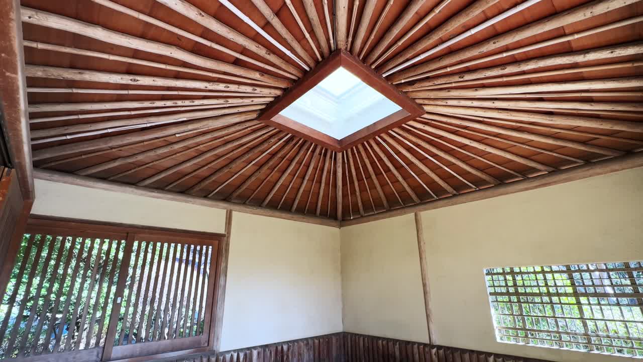 Natural wooden ceiling with beams radiating from a central skylight in a Japanese building