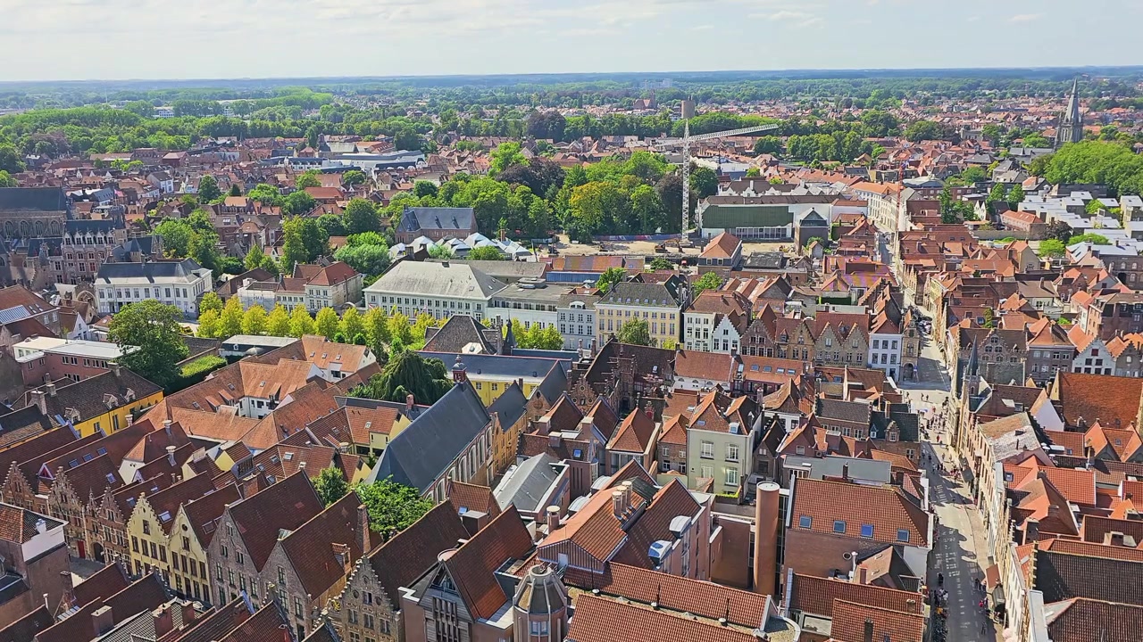 Vista panoramica su una vecchia città europea con tetti in terracotta, chiesa gotica, strade strette, edifici colorati, parchi verdi e cielo estivo azzurro brillante per video turistici e viaggi