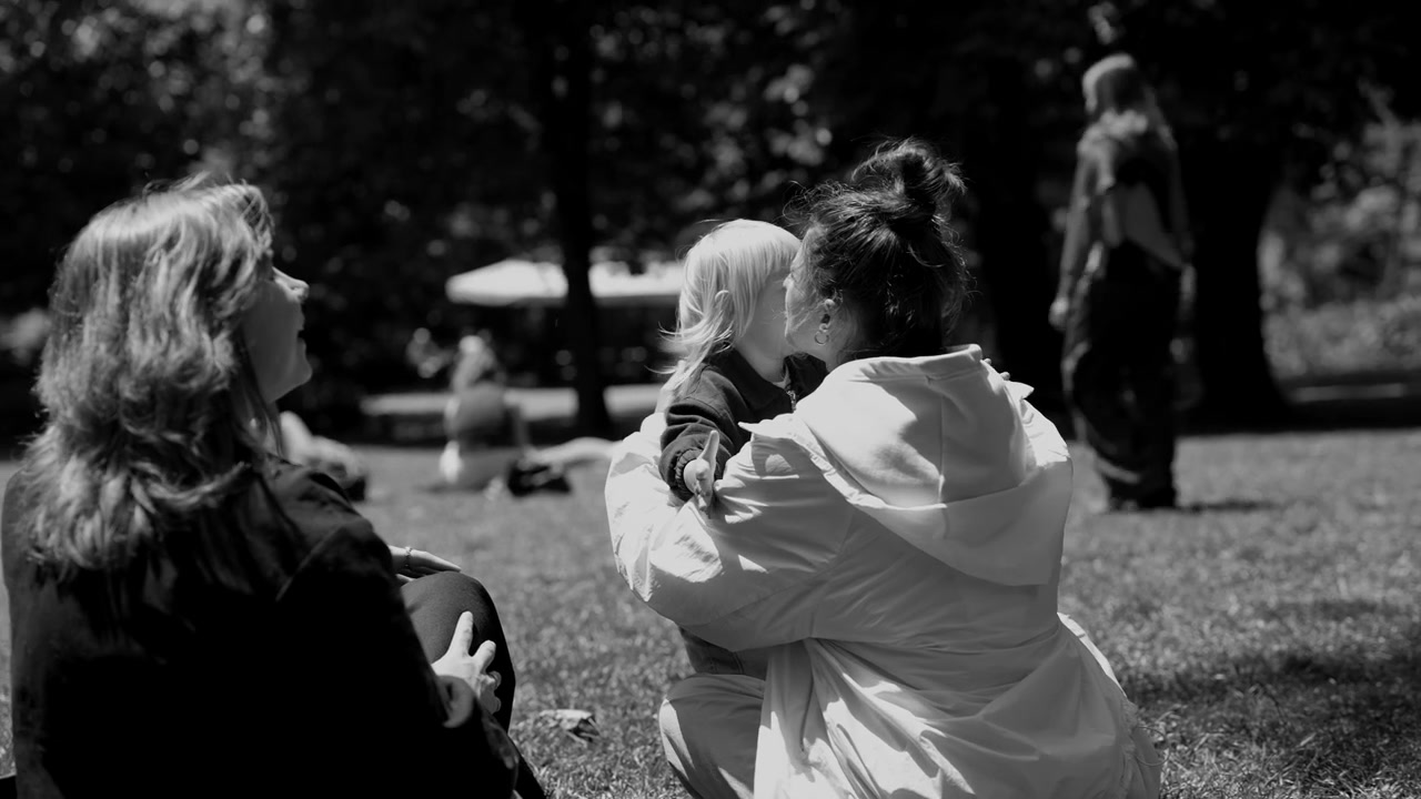 Bambino felice che gioca con delle donne in un parco soleggiato