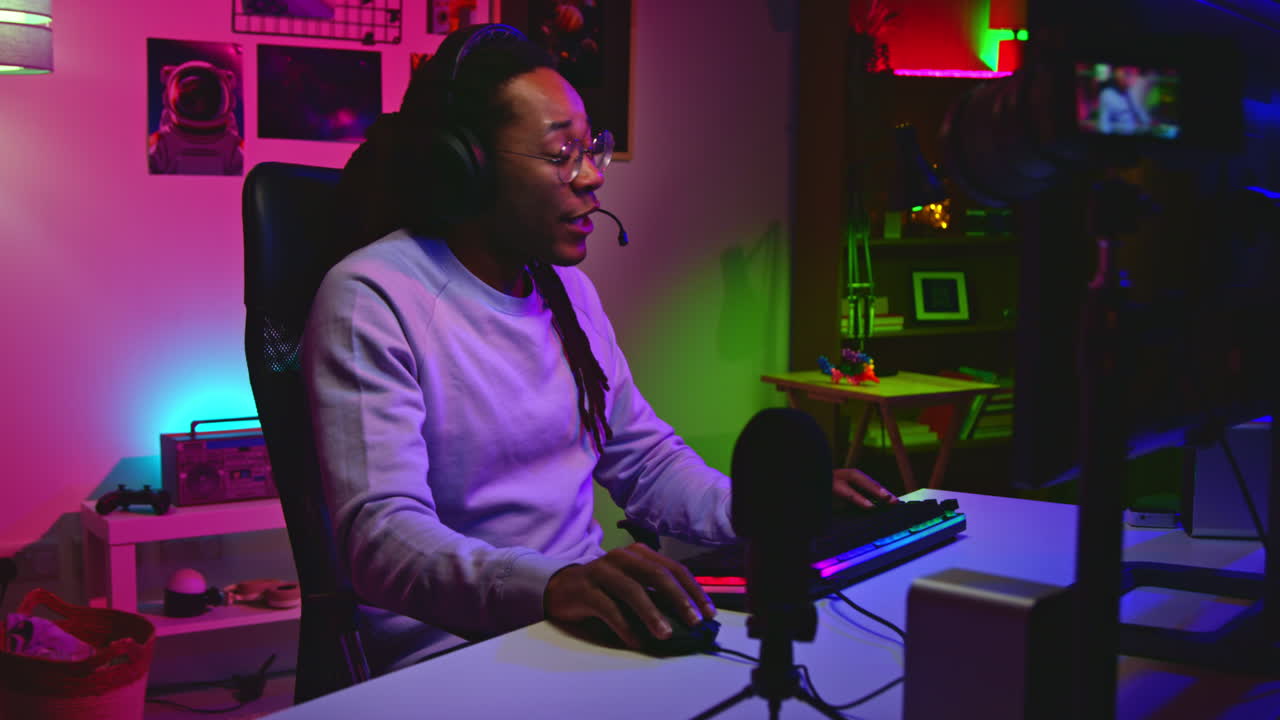 un hombre jugando videojuegos en su habitación por la noche.