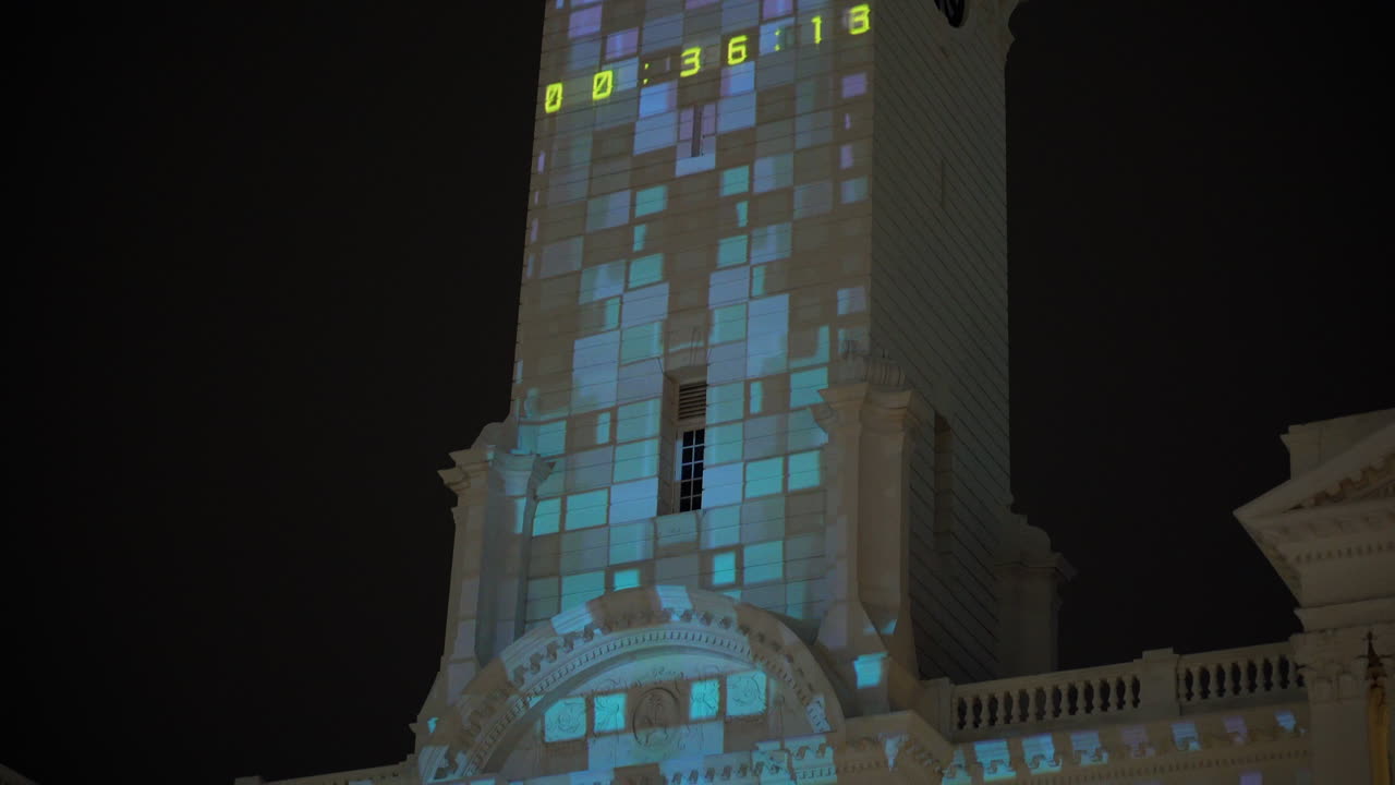 proyección de luz en la torre del reloj por la noche