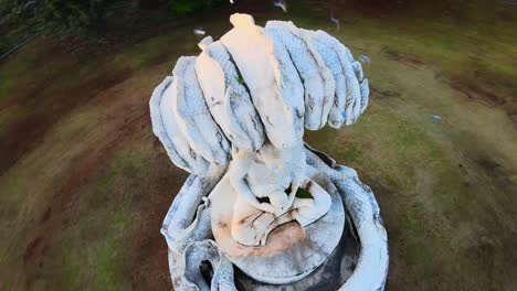 4k aerial around concrete naga buddha statue in the morning