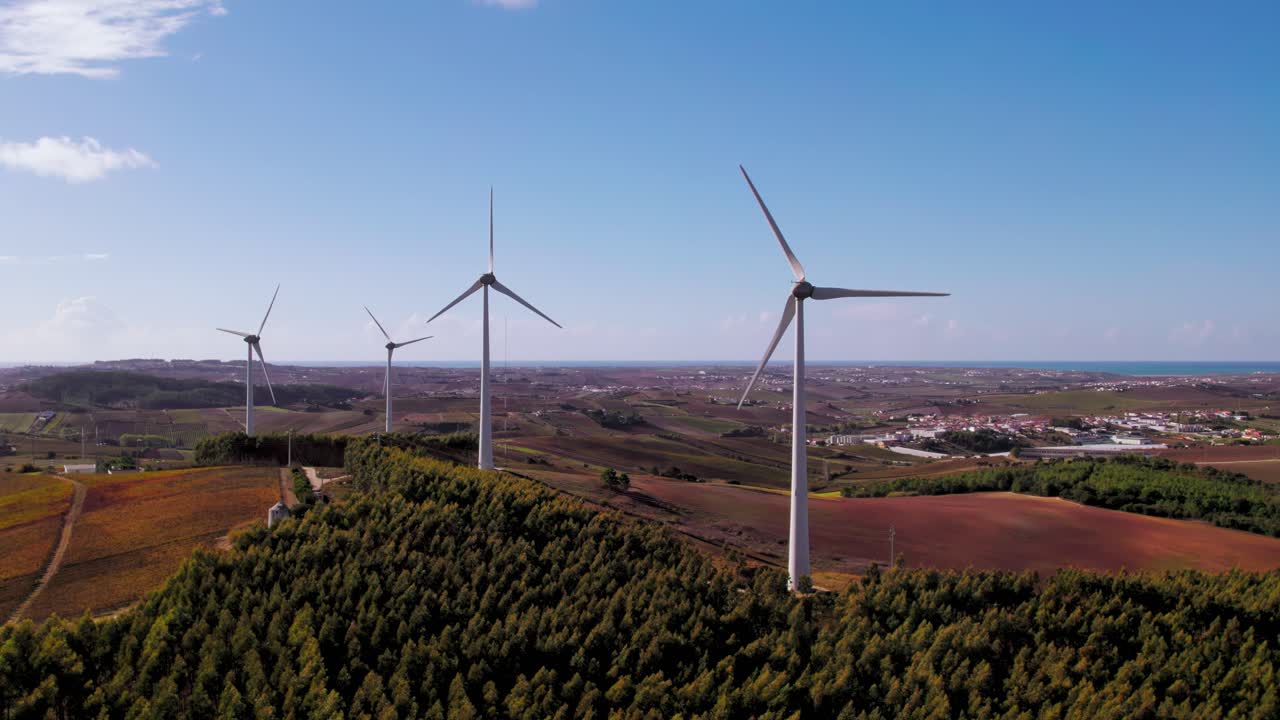 vista aérea de la zona rural de torres vedras, portugal, con varias turbinas eólicas que generan energía, volando hacia atrás