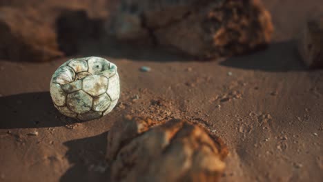 vieja pelota de fútbol en la playa de arena