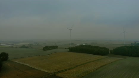 Aerial-footage-in-foggy-morning-at-the-wind-farm,-windmills-close-together-in-the-field