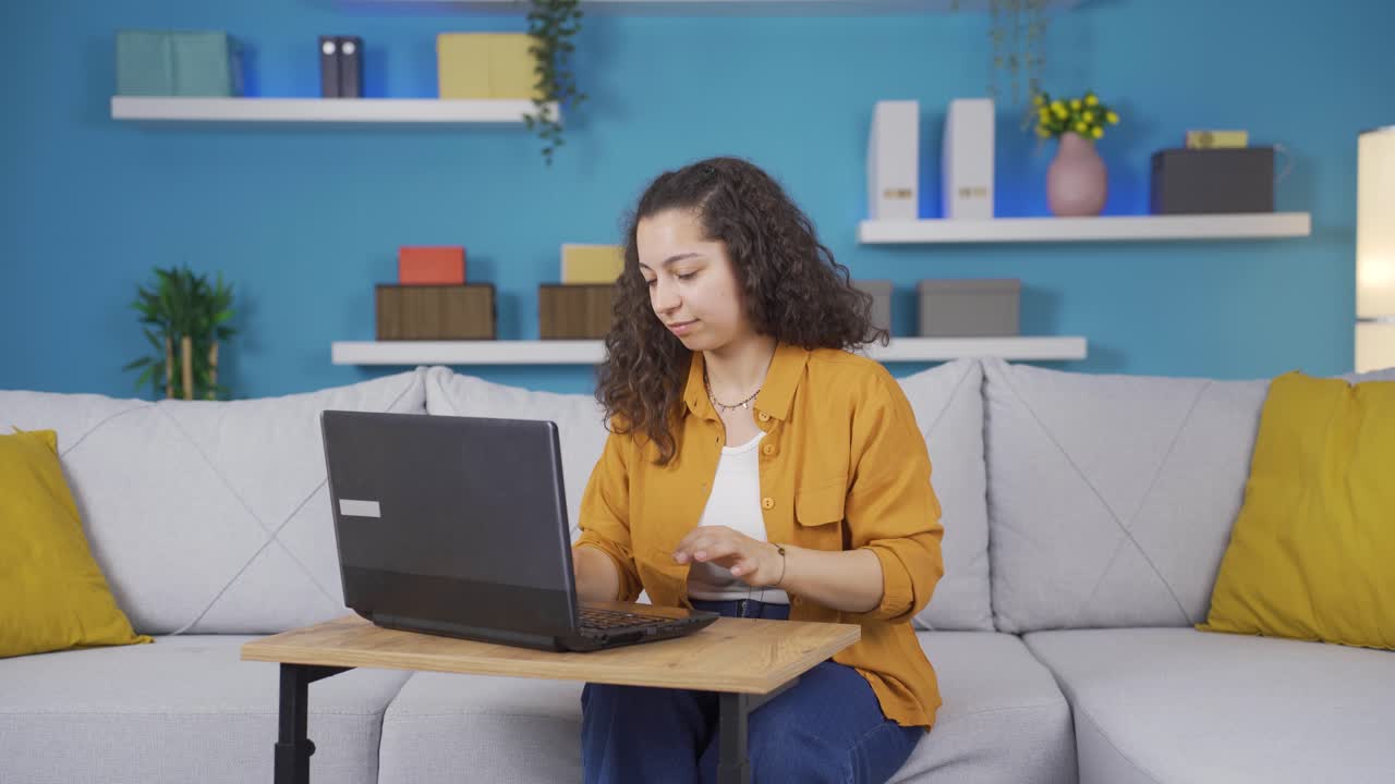 la joven que mira la computadora portátil está feliz y bailando.
