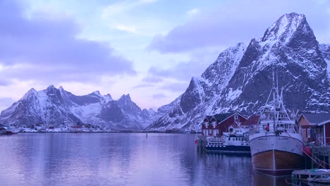 雪覆蓋的山峰和湖泊在北極的洛福頓群島 (lofoten islands) 裝飾一個偏遠的村莊