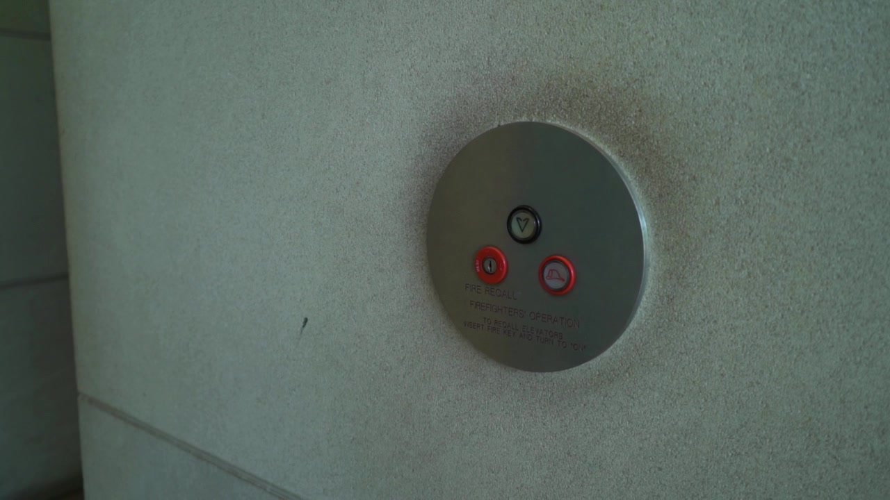 Man pushes elevator button and gets on elevator.
