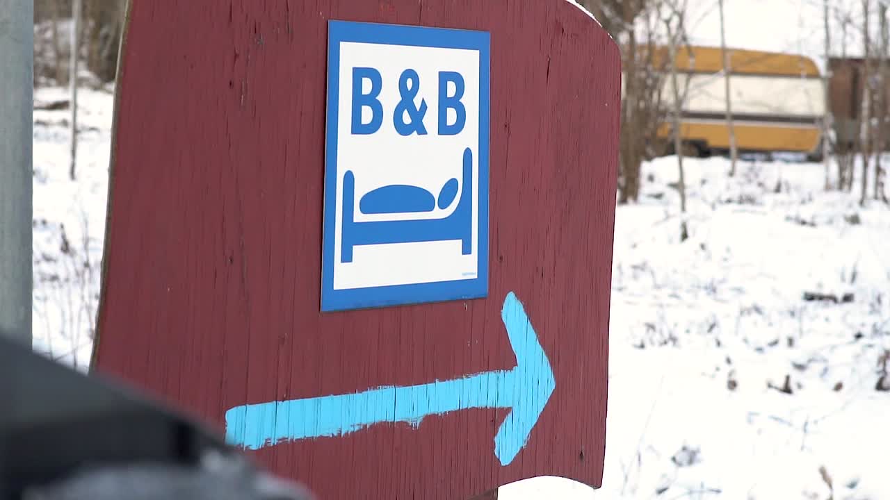 Directional sign for a bed and breakfast in snowy, quiet outdoor setting