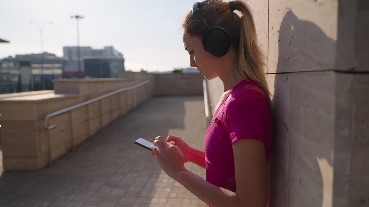 mujer al aire libre usando el teléfono mientras hace ejercicio