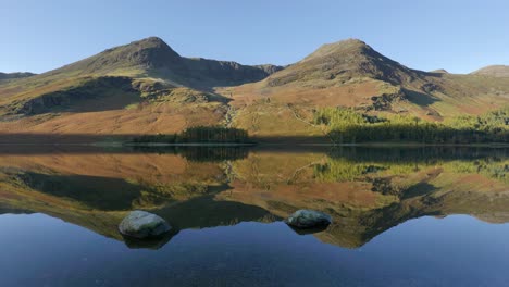 buttermere lake autumn reflections of high crag and high stile in the calm waters, cumbria, england