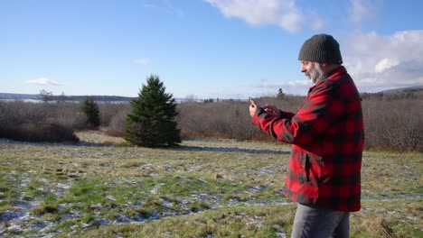 a man using his cell phone on a walk in the countryside. stock video.