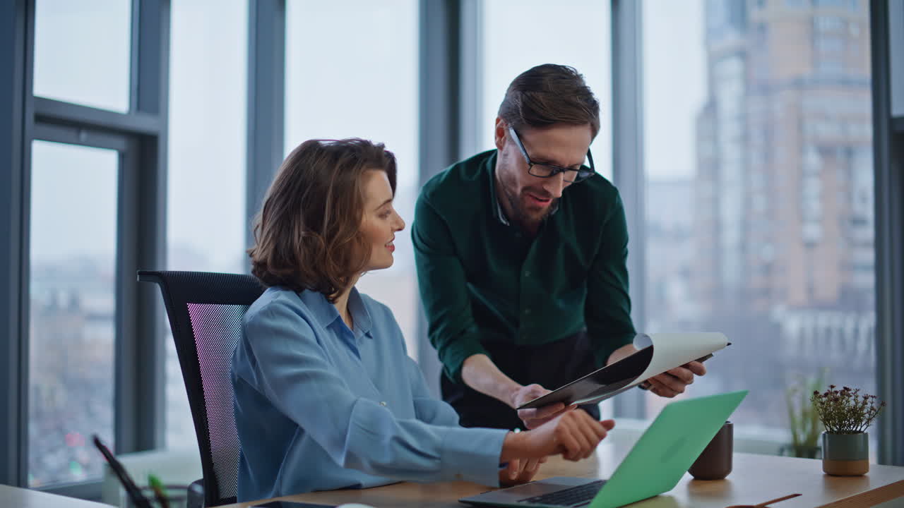 Businessman consulting woman manager with documentation at laptop desk closeup