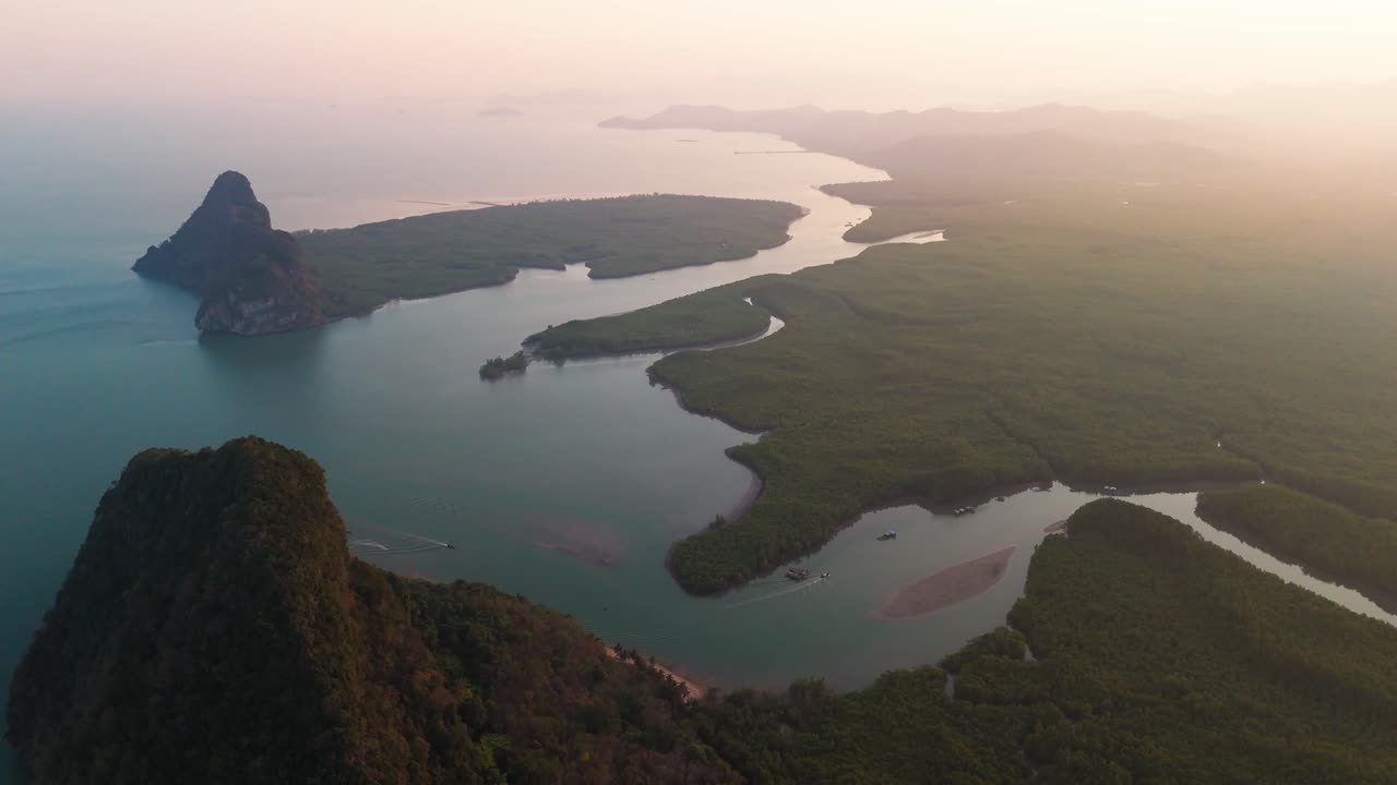 Thailand Aerial overview of Phang Nga Bay at sunrise, limestone cliffs, winding waterways, and calm reflective waters