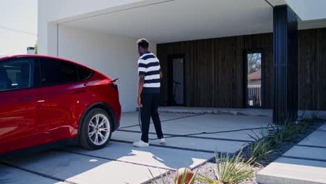 hombre cargando coche eléctrico en casa