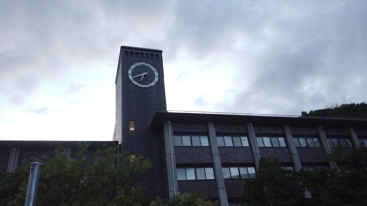 Panoramica lenta dal basso della Torre dell'Orologio dell'Università Ritsumeikan all'ora blu a Kyoto, Giappone
