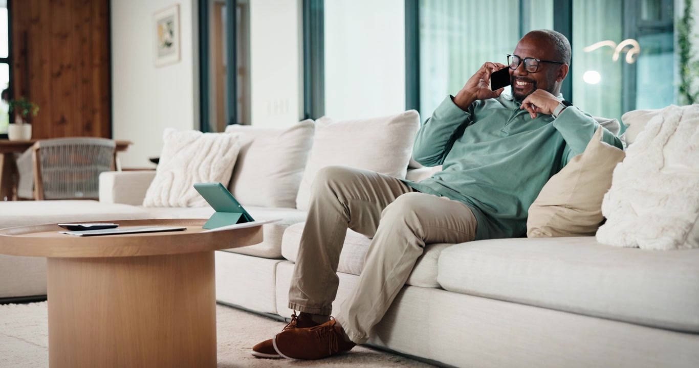 Mature African American Man Talking on Smartphone on Sofa