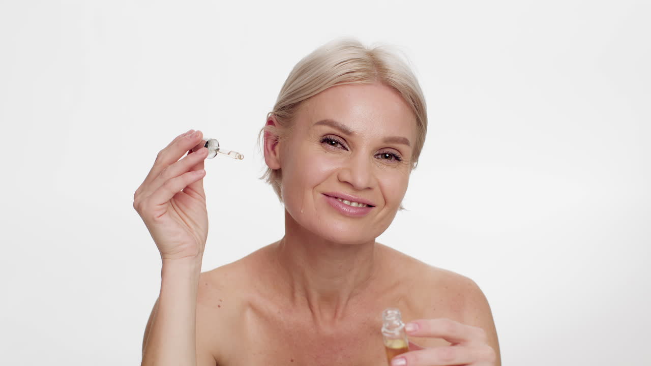 Mujer madura aplicando sérum facial