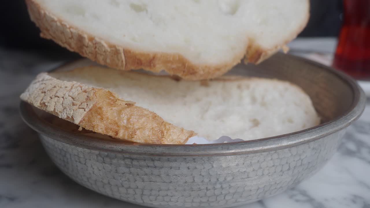 Close Up of Hand Taking a Slice of Fresh Bread from a Bowl