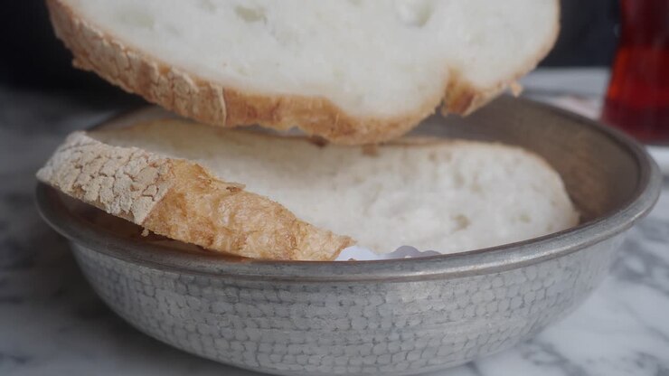 Close Up of Hand Taking a Slice of Fresh Bread from a Bowl