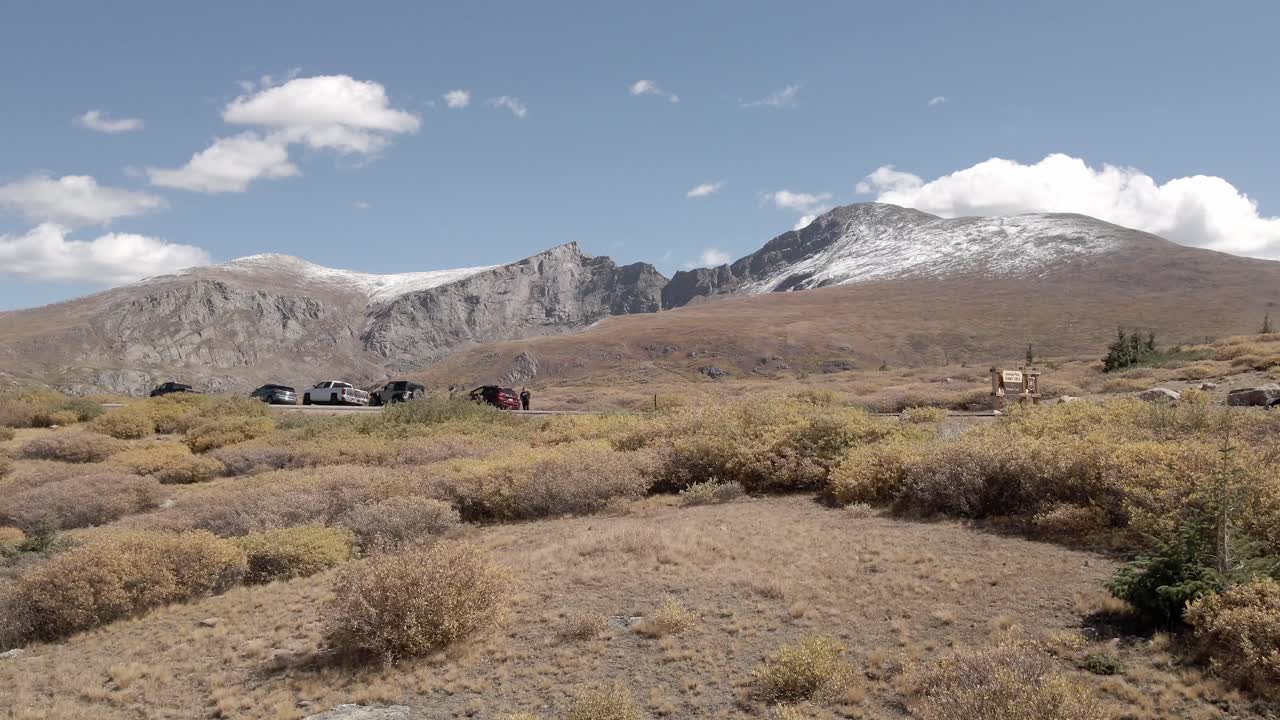 vista aérea que revela un paso de montaña en un alto valle alpino con el monte cielo azul y bierstadt en la distancia con nieve. filmado cerca del paso de guanella, colorado durante el otoño.