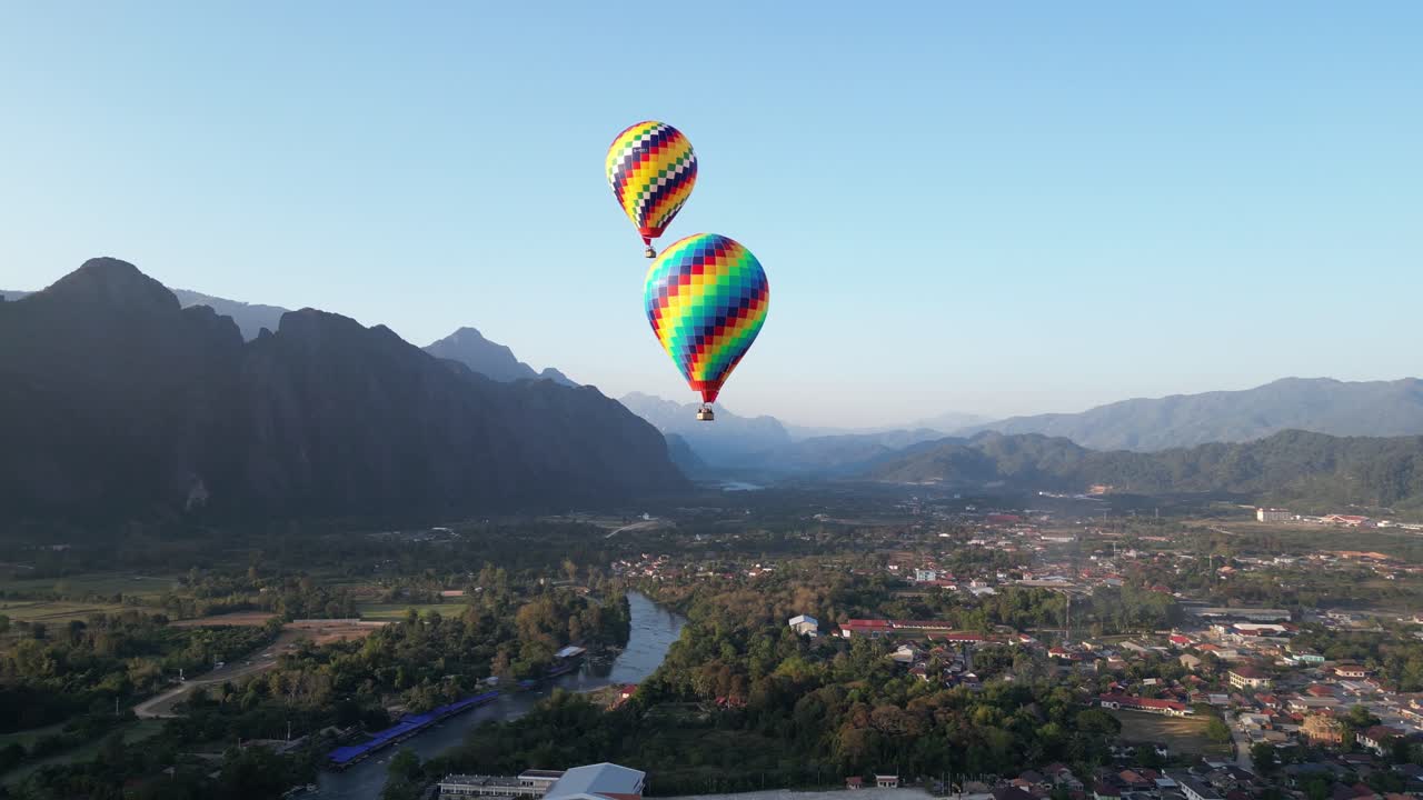 tomada aérea de globos de aire caliente sobre el río en vang vieng, la capital de la aventura de laos