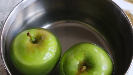 green apples are turning in pot of water and video is looping