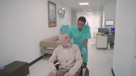 an old man with a beard and gray hair is dragged by a young female nurse in his wheelchair