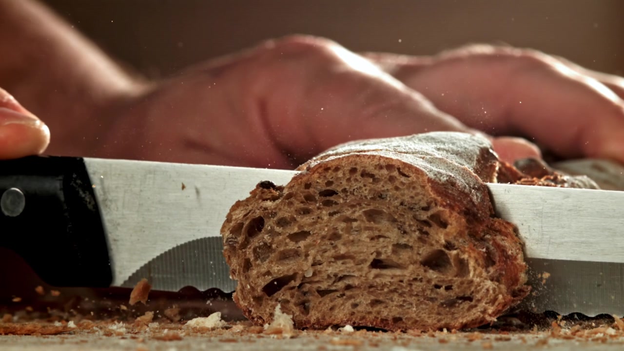 Slow Motion Close-up of Slicing Fresh Rustic Bread