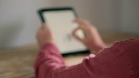 persona que utiliza una tableta para comprar en línea o hacer videollamas