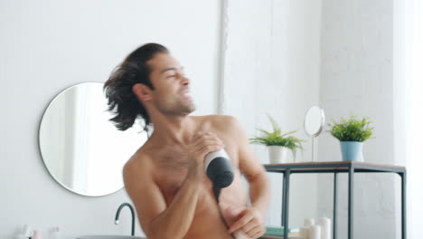 man singing in bathroom with hair dryer