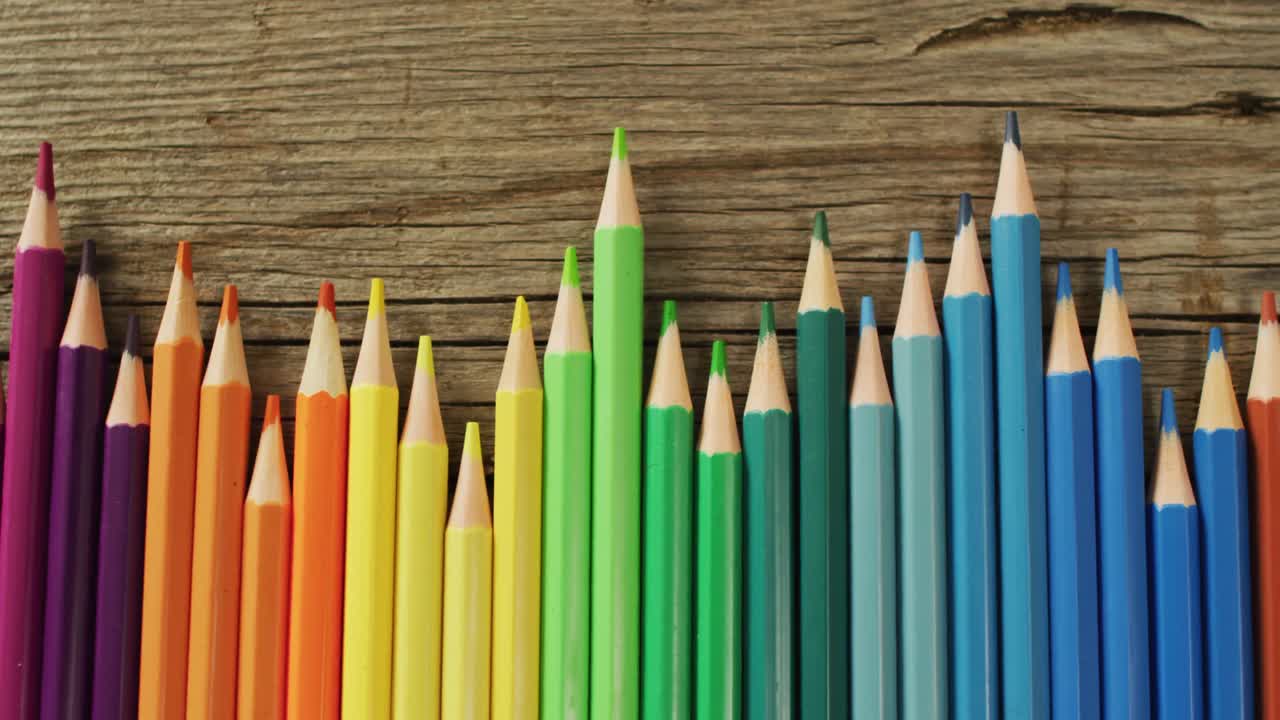 video de composición con lápices de colores en superficie de madera