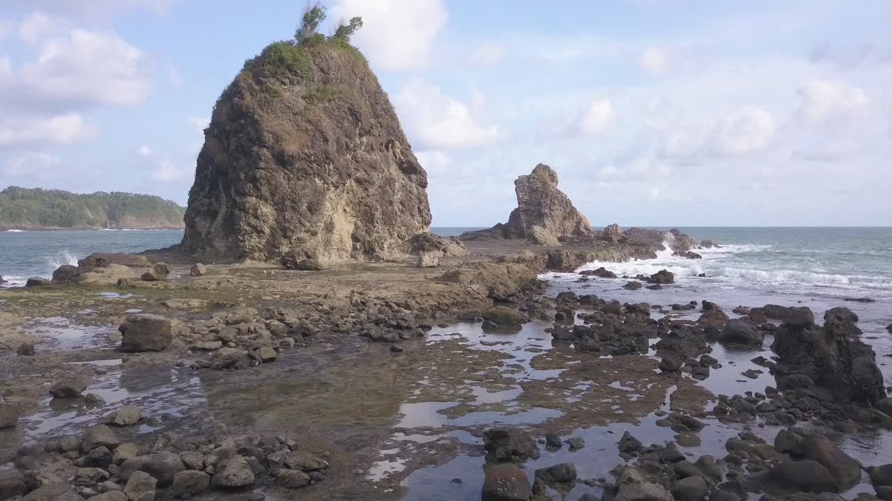 Watu Lumbung Beach in Gunungkidul, Yogyakarta. A beach with unique large rocks and corals. The waves crash against each coral.