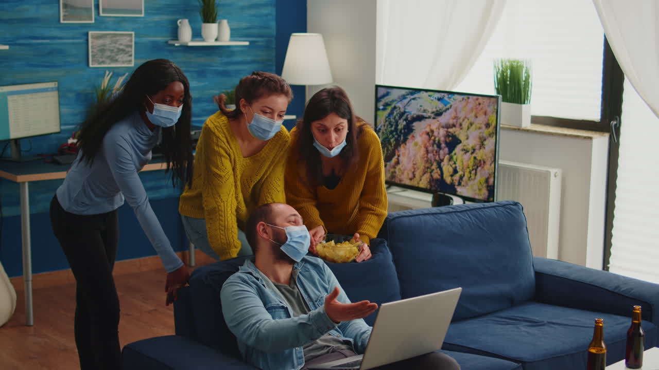 Cheerful happy multi ethnic friends looking at photo on laptop