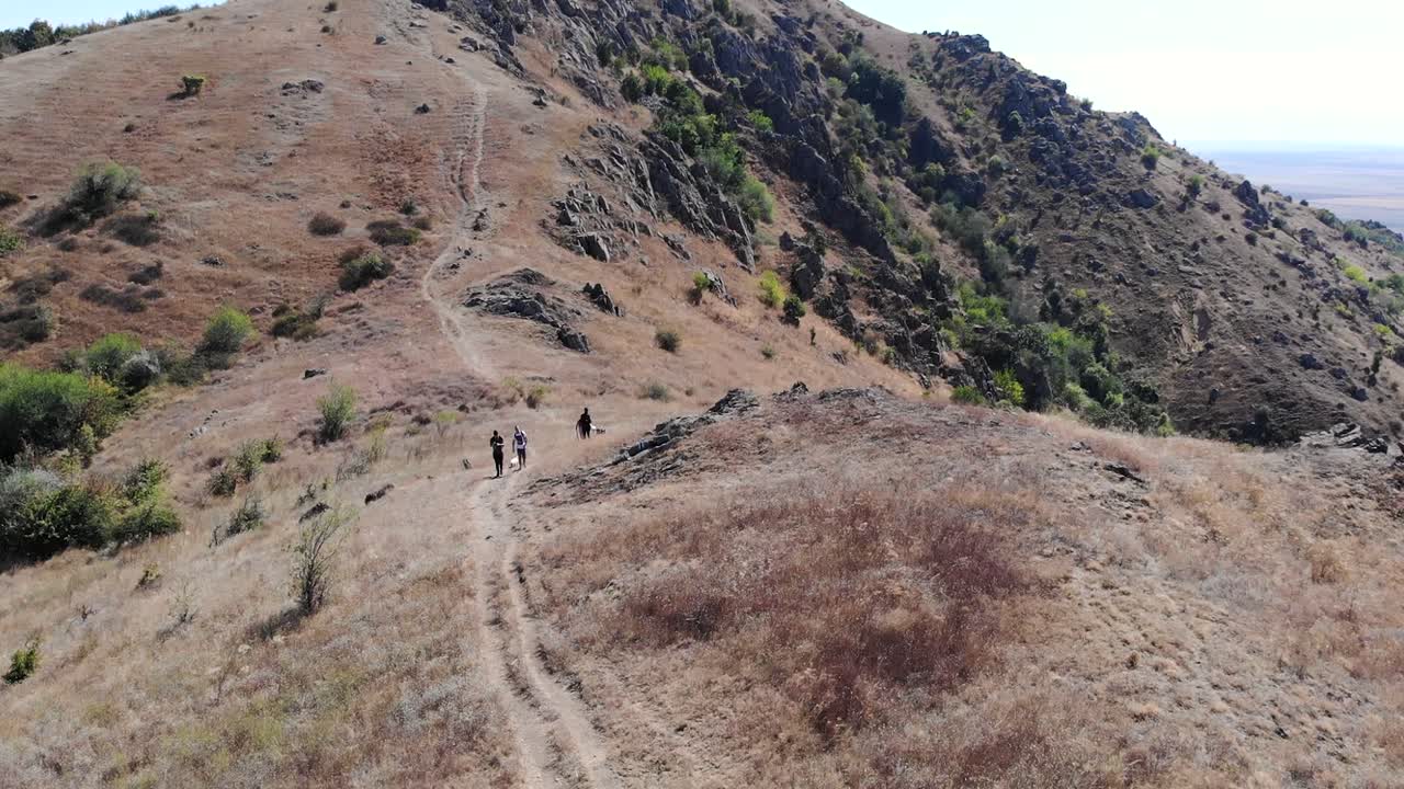 excursionistas caminando por el sendero en la cordillera macin en un día soleado de verano en tulcea, dobrogea, rumania