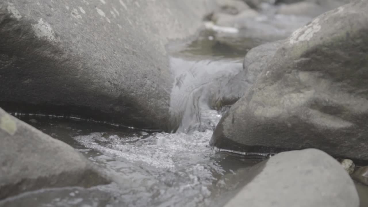 슬로우 모션으로 두 개의 바위 사이를 흐르는 물줄기
