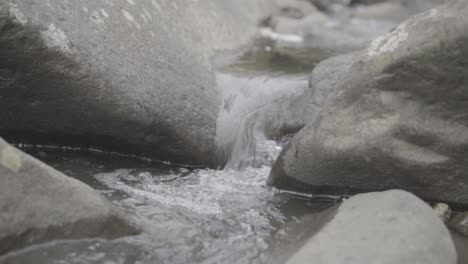 Stream-of-water-flowing-between-two-rocks-in-slow-motion