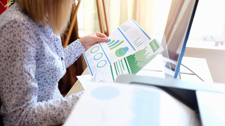 Woman Analyzing Financial Charts at Office