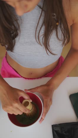 a person whisking matcha tea in a bowl