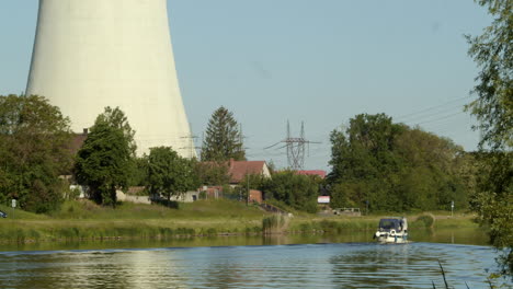 Lancha-En-Un-Río-Navega-Más-Allá-De-La-Torre-De-Refrigeración-De-Una-Central-Eléctrica-De-Carbón