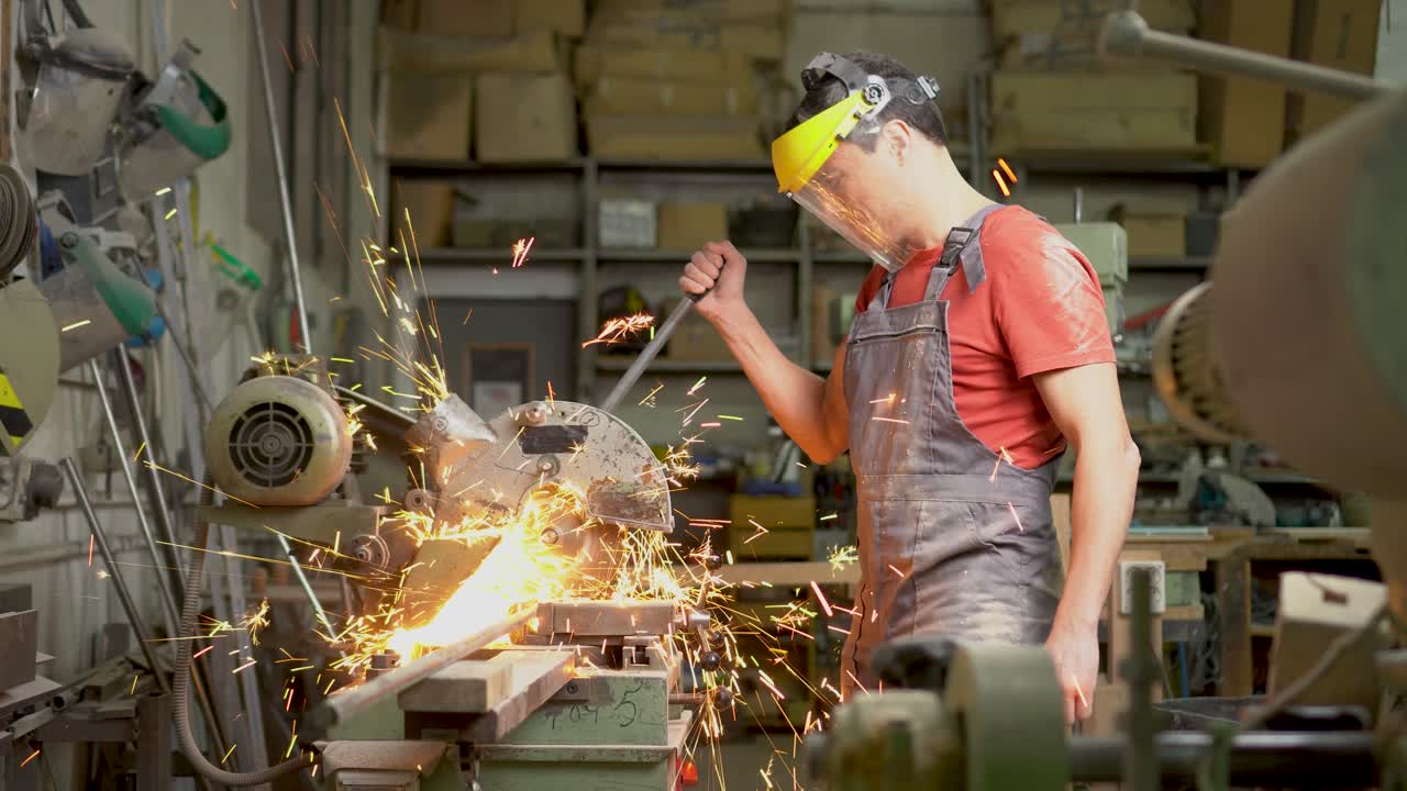 Worker cutting metal with a saw in a workshop