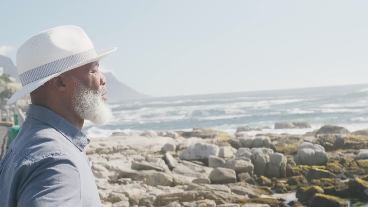 hombre afroamericano anciano feliz en el paseo marítimo, espacio de copia, cámara lenta