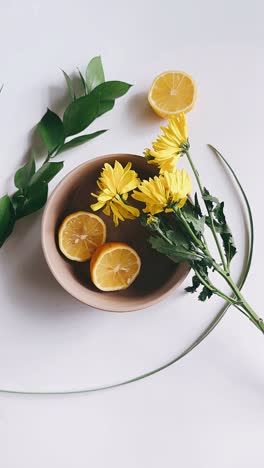 lemons and yellow flowers in a bowl