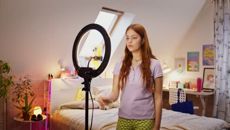 teenage girl recording video in bedroom