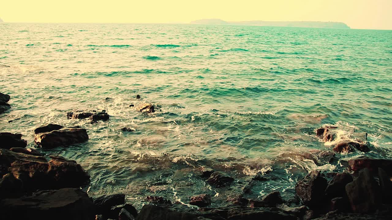 escena cinematográfica oscura y de mal humor de las olas chocando contra las rocas