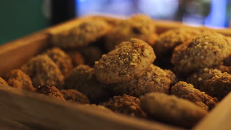 Pastry-canister-full-of-backed-biscuits-with-nuts-and-seeds,-macro-slow-motion-shot